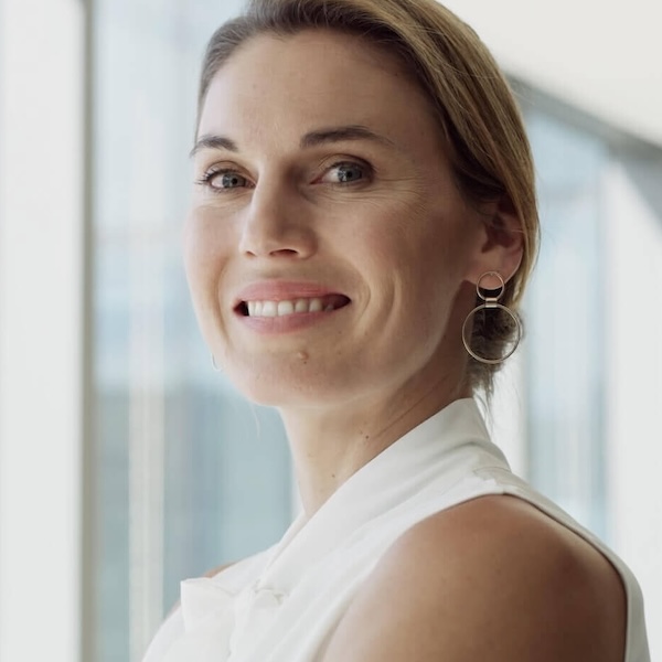 Frau im Finanzsektor blickt den Betrachter freundlich an.